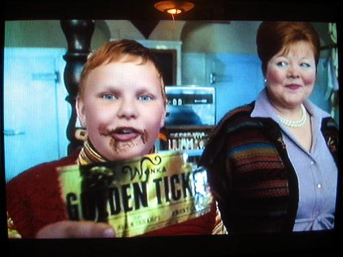 Augustus Gloop holding the Golden Ticket in Charlie and the Chocolate Factory